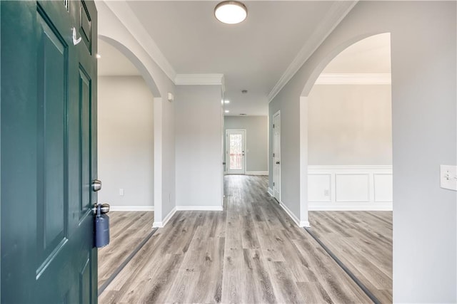 entrance foyer featuring ornamental molding and light hardwood / wood-style flooring