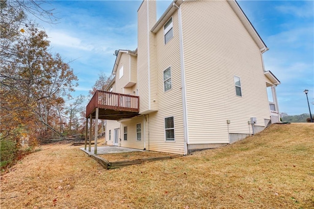 rear view of house featuring a deck, a yard, and a patio