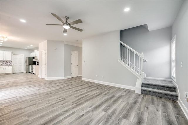 unfurnished living room featuring ceiling fan and light hardwood / wood-style flooring