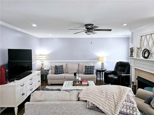 living room featuring dark hardwood / wood-style flooring, a high end fireplace, ornamental molding, and ceiling fan