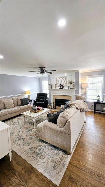 living room with ceiling fan and dark hardwood / wood-style flooring