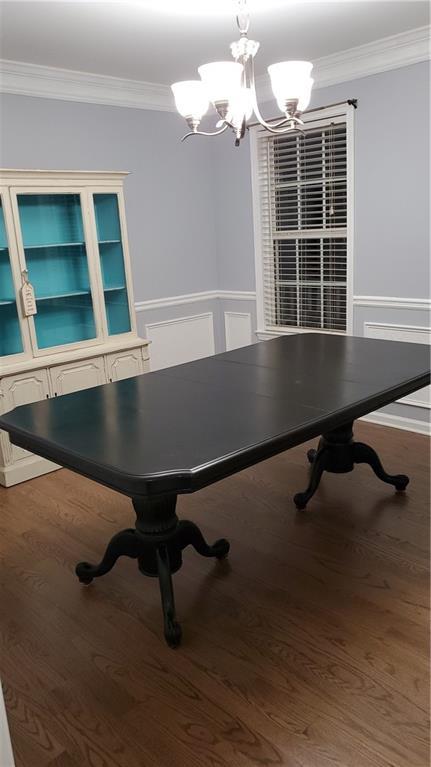 recreation room with ornamental molding, a chandelier, and wood-type flooring