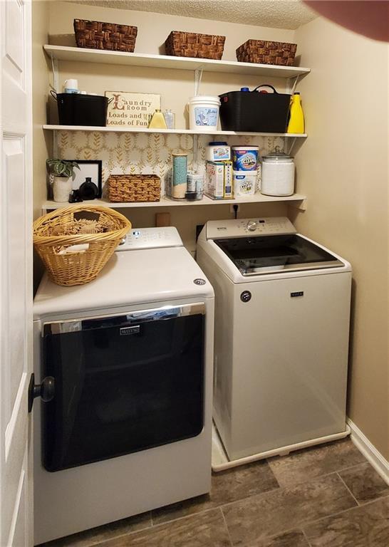 laundry area featuring a textured ceiling and washer and clothes dryer