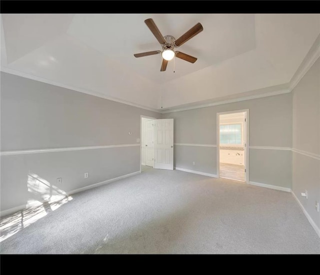 spare room featuring ceiling fan, light colored carpet, ornamental molding, and a tray ceiling