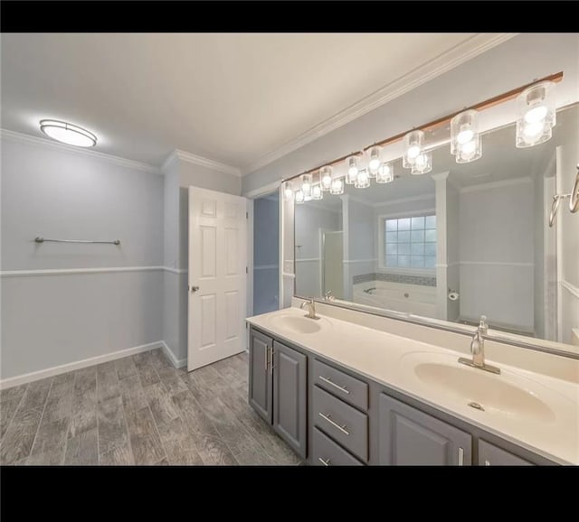 bathroom featuring ornamental molding, hardwood / wood-style floors, vanity, and a tub