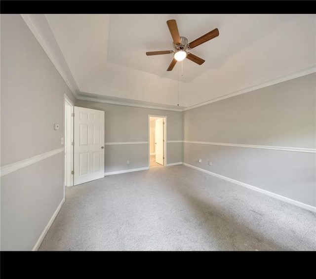 carpeted spare room with ceiling fan and a raised ceiling