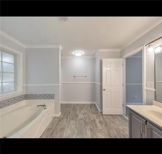 bathroom with hardwood / wood-style flooring, vanity, crown molding, and a tub to relax in