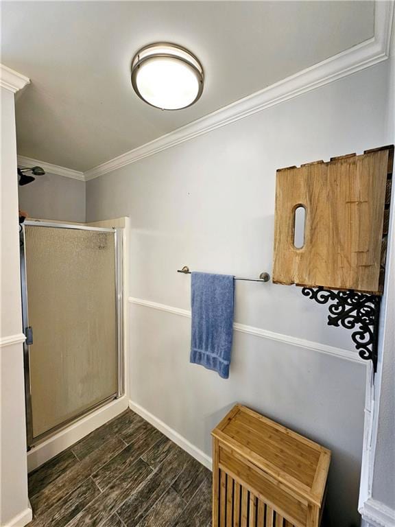 bathroom featuring hardwood / wood-style flooring, crown molding, and a shower with door