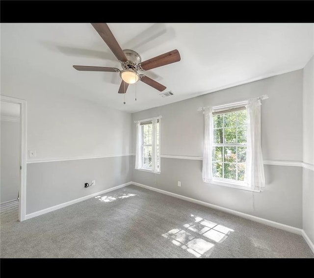 unfurnished room with plenty of natural light, carpet floors, and ceiling fan