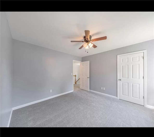 unfurnished bedroom featuring ceiling fan and carpet