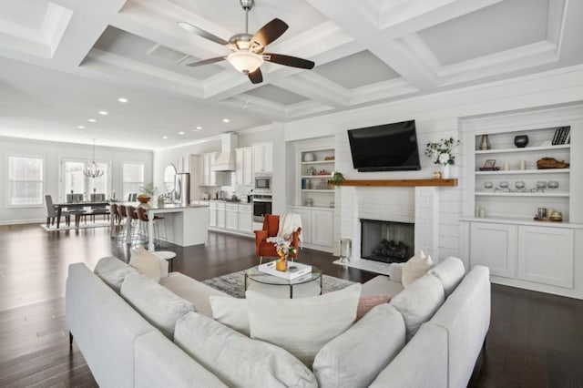 living area featuring beamed ceiling, coffered ceiling, and dark wood-type flooring