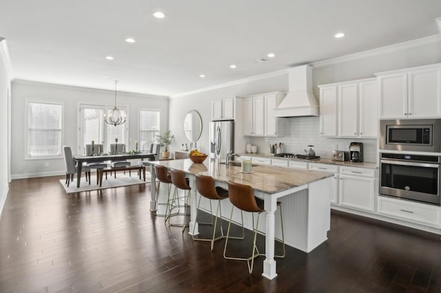 kitchen featuring a breakfast bar, custom range hood, ornamental molding, decorative backsplash, and stainless steel appliances