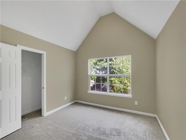 unfurnished bedroom featuring lofted ceiling and carpet flooring