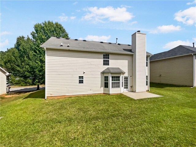 back of property with a patio area and a yard