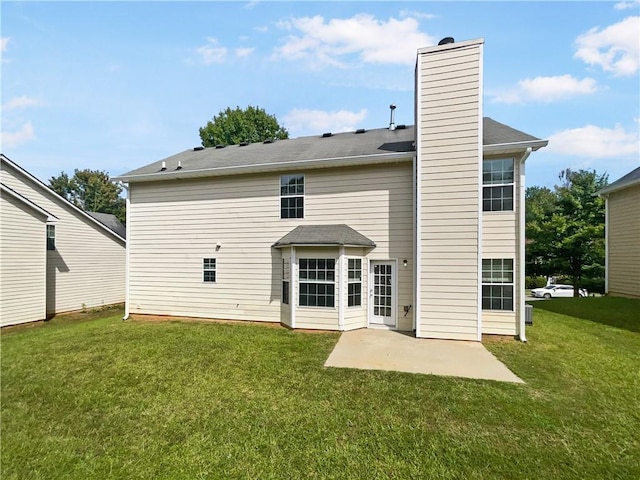 back of house with a patio, a yard, and a chimney