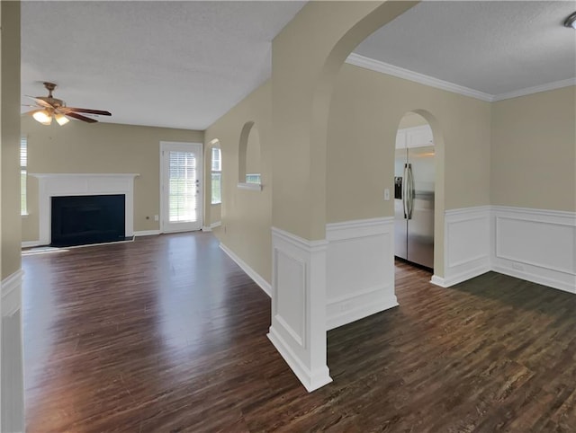 interior space with dark wood-type flooring, ceiling fan, crown molding, and a textured ceiling