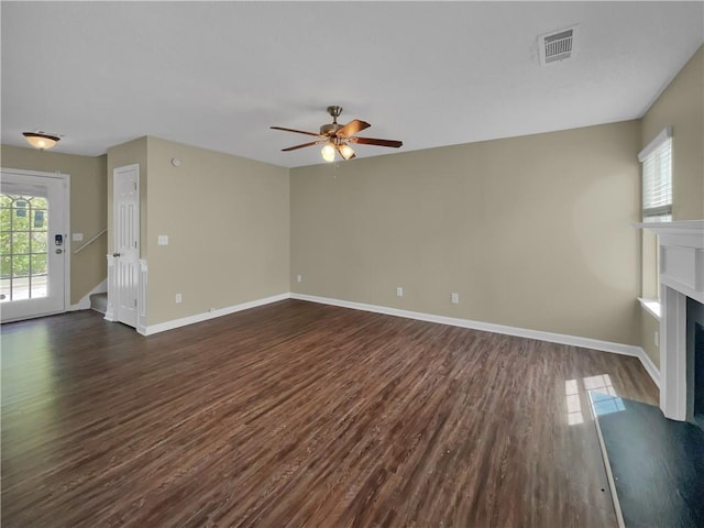 unfurnished living room featuring visible vents, a fireplace with flush hearth, baseboards, and dark wood-style flooring