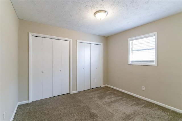 8775 Lee Rd, Lithia Springs, GA 30122 - unfurnished bedroom featuring carpet flooring, multiple closets, and a textured ceiling