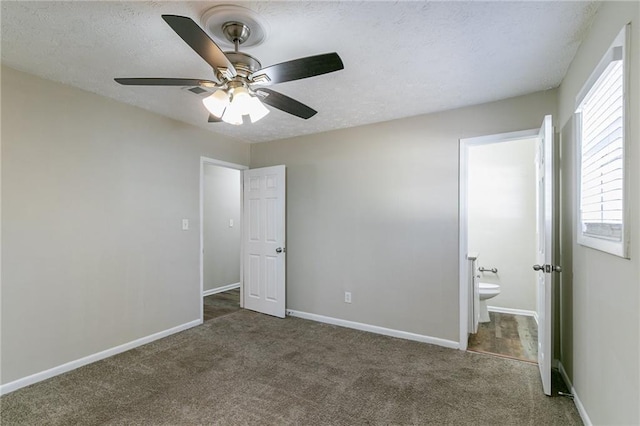 8775 Lee Rd, Lithia Springs, GA 30122 - unfurnished bedroom with ceiling fan, dark carpet, a textured ceiling, and ensuite bath