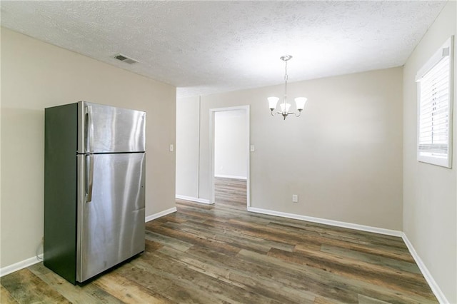 8775 Lee Rd, Lithia Springs, GA 30122 - kitchen featuring dark wood-type flooring, stainless steel fridge, a chandelier, pendant lighting, and a textured ceiling