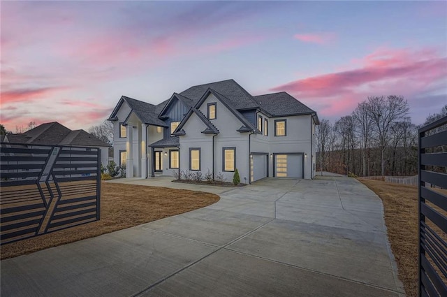 view of front of house with an attached garage, fence, concrete driveway, roof with shingles, and stucco siding