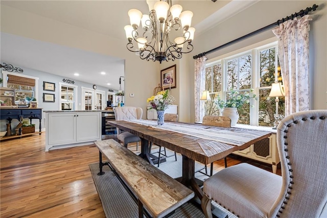 dining area with beverage cooler, recessed lighting, a chandelier, and light wood-type flooring