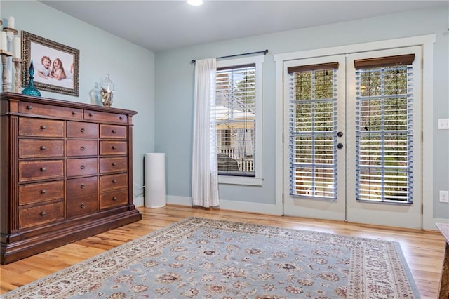 doorway to outside with baseboards, french doors, and light wood-style floors