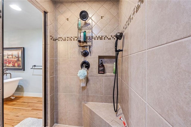 full bath featuring baseboards, tiled shower, wood finished floors, and a freestanding bath