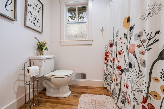 full bathroom with toilet, baseboards, curtained shower, wood finished floors, and visible vents