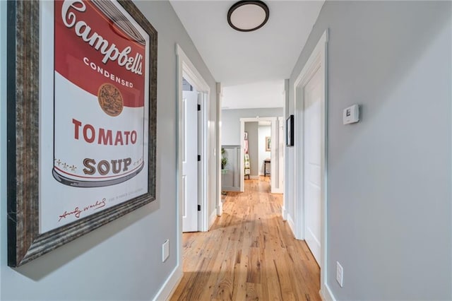 corridor with baseboards and wood finished floors
