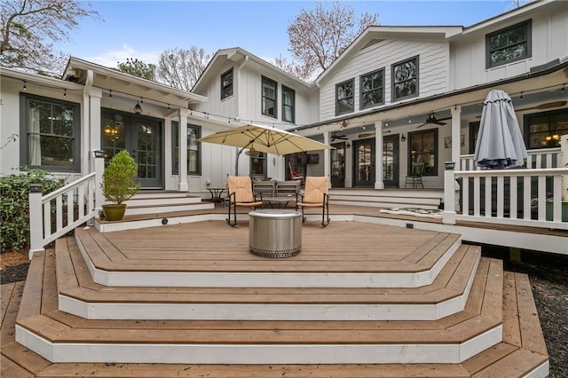 rear view of house with a ceiling fan, board and batten siding, and a deck