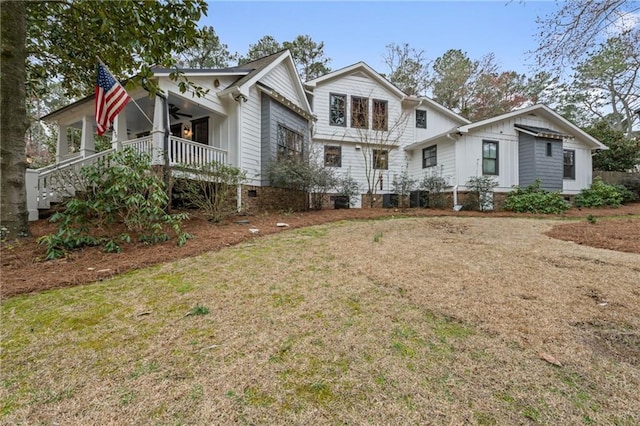 view of front of property featuring a ceiling fan, board and batten siding, a porch, and a front yard