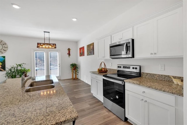 kitchen featuring pendant lighting, sink, stainless steel appliances, and white cabinets