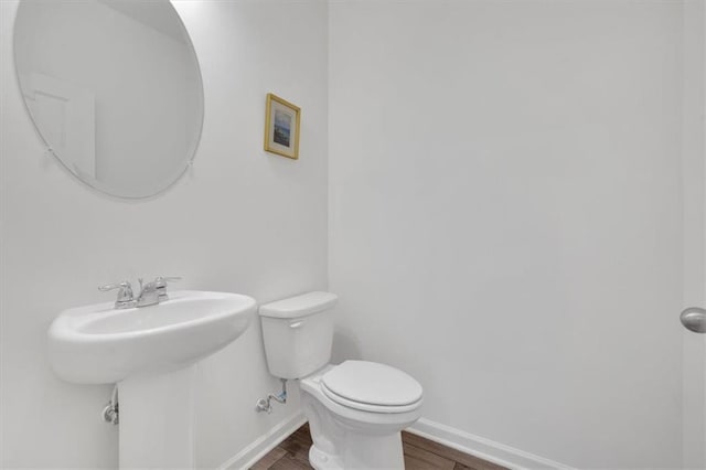 bathroom featuring wood-type flooring and toilet