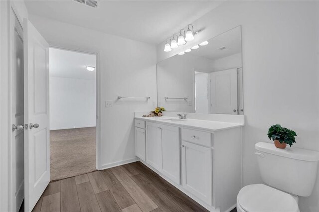 bathroom with vanity, hardwood / wood-style floors, and toilet