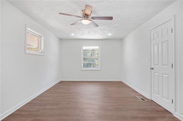 unfurnished room featuring ceiling fan, wood-type flooring, and a textured ceiling