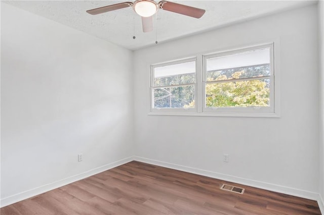 spare room with a textured ceiling, hardwood / wood-style flooring, and ceiling fan