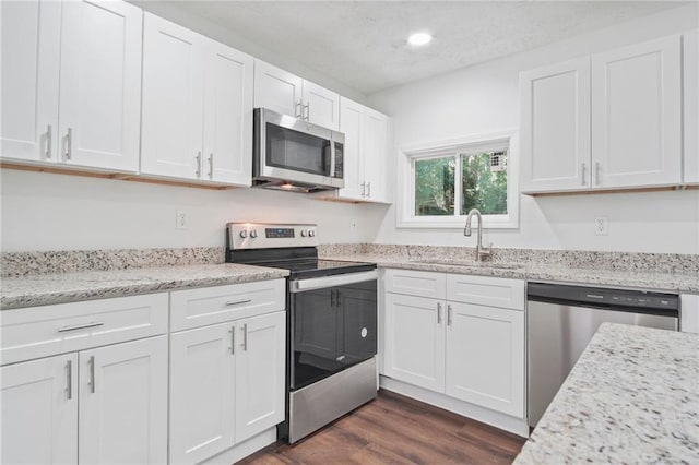 kitchen featuring dark hardwood / wood-style floors, white cabinetry, sink, and appliances with stainless steel finishes