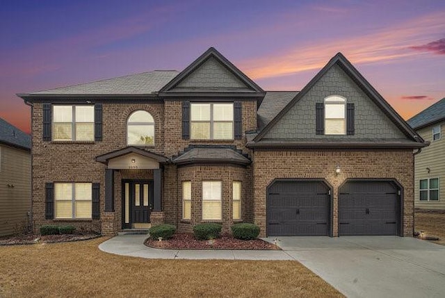 view of front of property with a yard, brick siding, and driveway