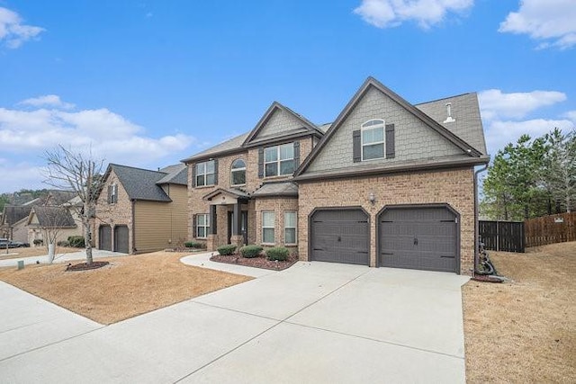 craftsman house with a garage, brick siding, concrete driveway, and fence