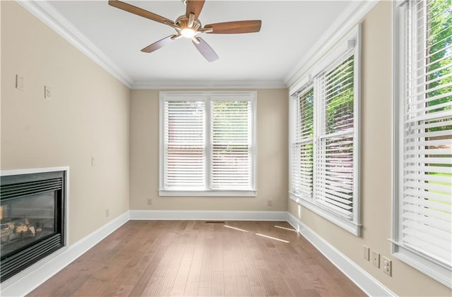 3394 Bryerstone Cir SE, Smyrna, GA 30080 - unfurnished living room featuring wood finished floors, ornamental molding, a glass covered fireplace, baseboards, and ceiling fan