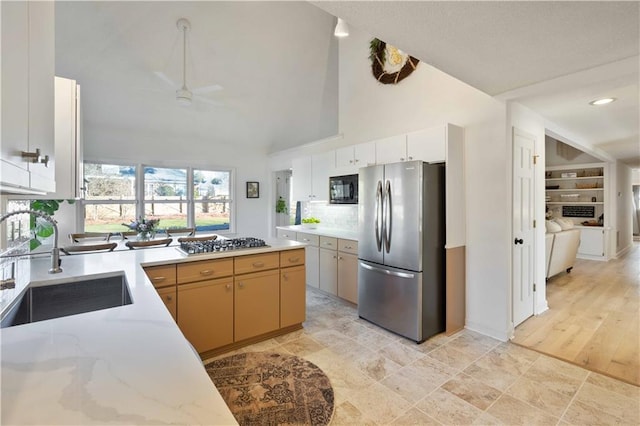 kitchen featuring sink, white cabinetry, high vaulted ceiling, ceiling fan, and stainless steel appliances