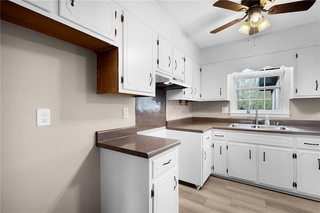 kitchen featuring ceiling fan, white cabinetry, sink, and light wood-type flooring