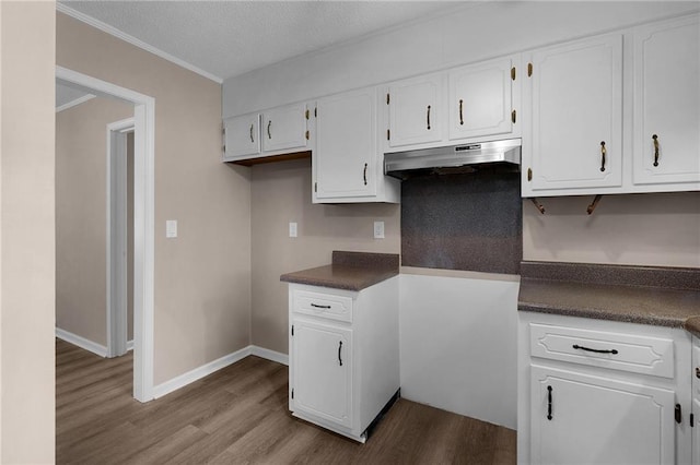 kitchen featuring white cabinetry, light wood-type flooring, a textured ceiling, and crown molding