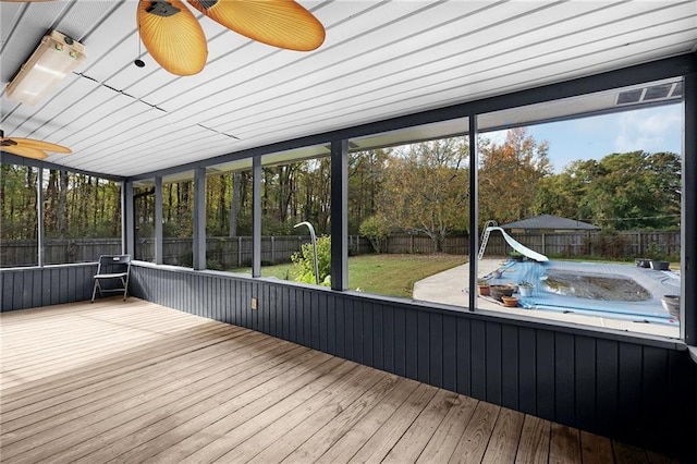 unfurnished sunroom featuring ceiling fan