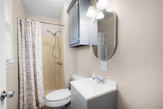 bathroom featuring toilet, vanity, and a shower with shower curtain