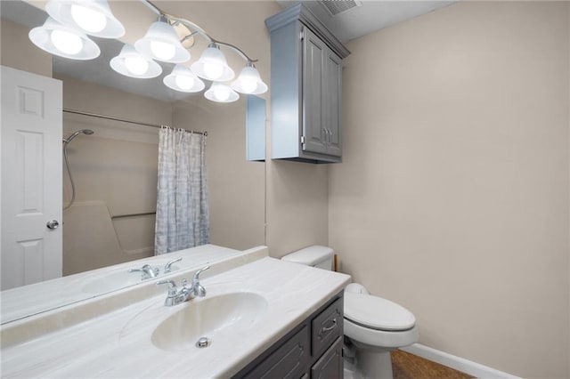 bathroom with toilet, vanity, and curtained shower