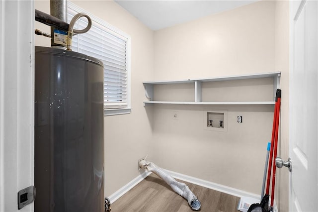 washroom with water heater, hookup for a washing machine, and hardwood / wood-style floors