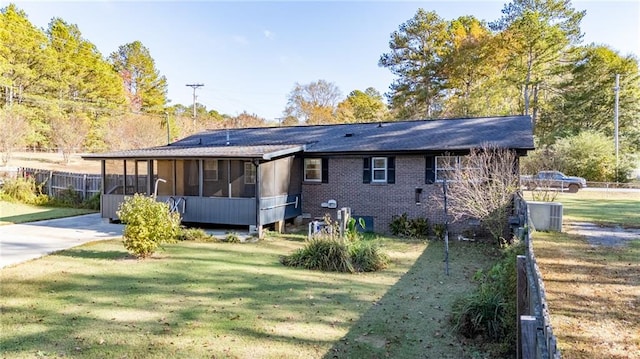 back of house with cooling unit, a lawn, and a sunroom