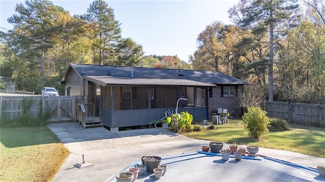 back of property with a patio area, a sunroom, and a yard